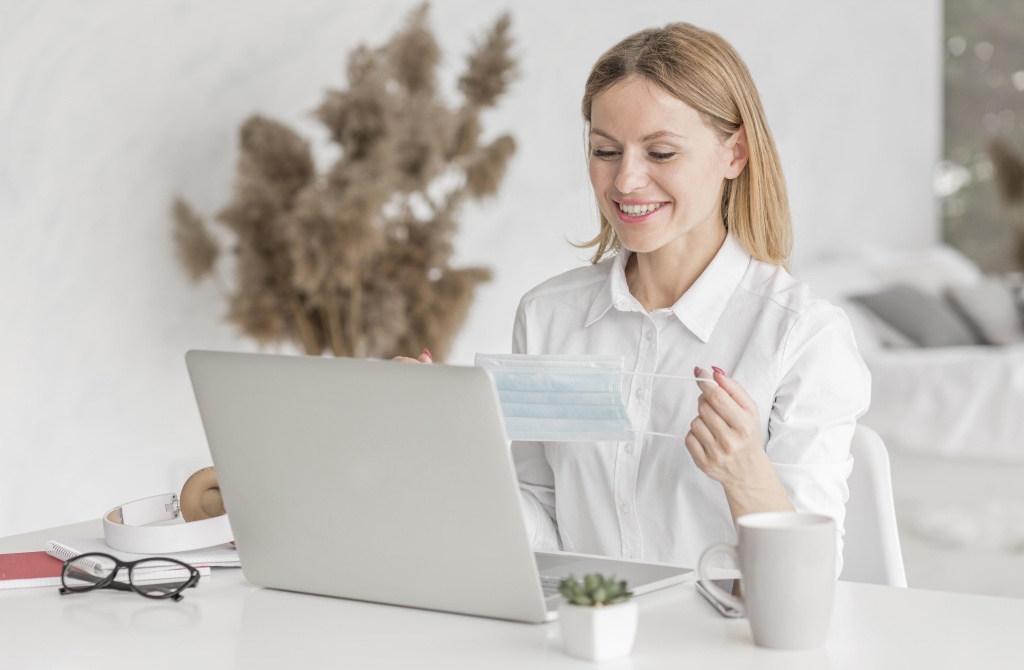 young-woman-studying-laptop-while-holding-medical-mask.jpg ноутбук